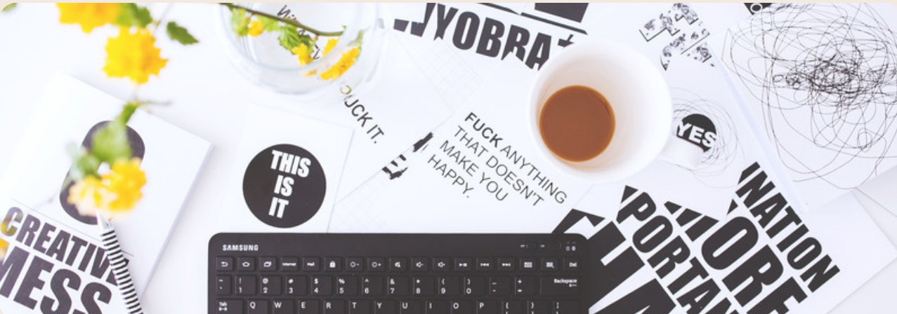 Desk covered in typographic prints and coffee